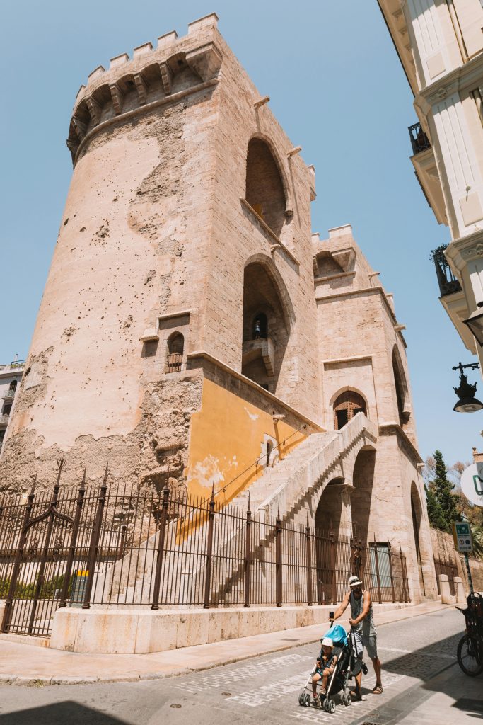 Sunlit view of the historic Quart Towers in Valencia, Spain captured at street level.